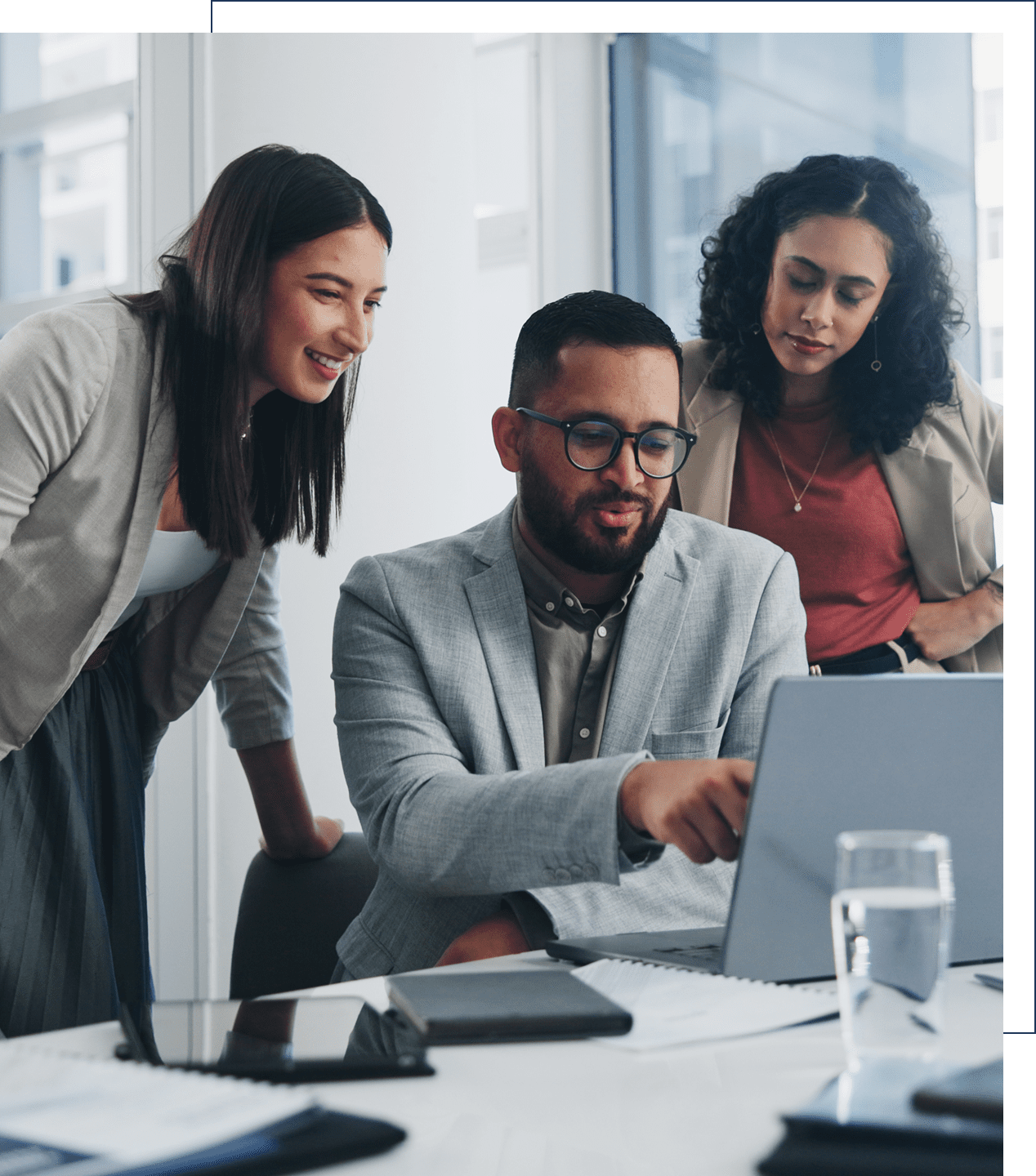Three colleagues collaborating at office computer.